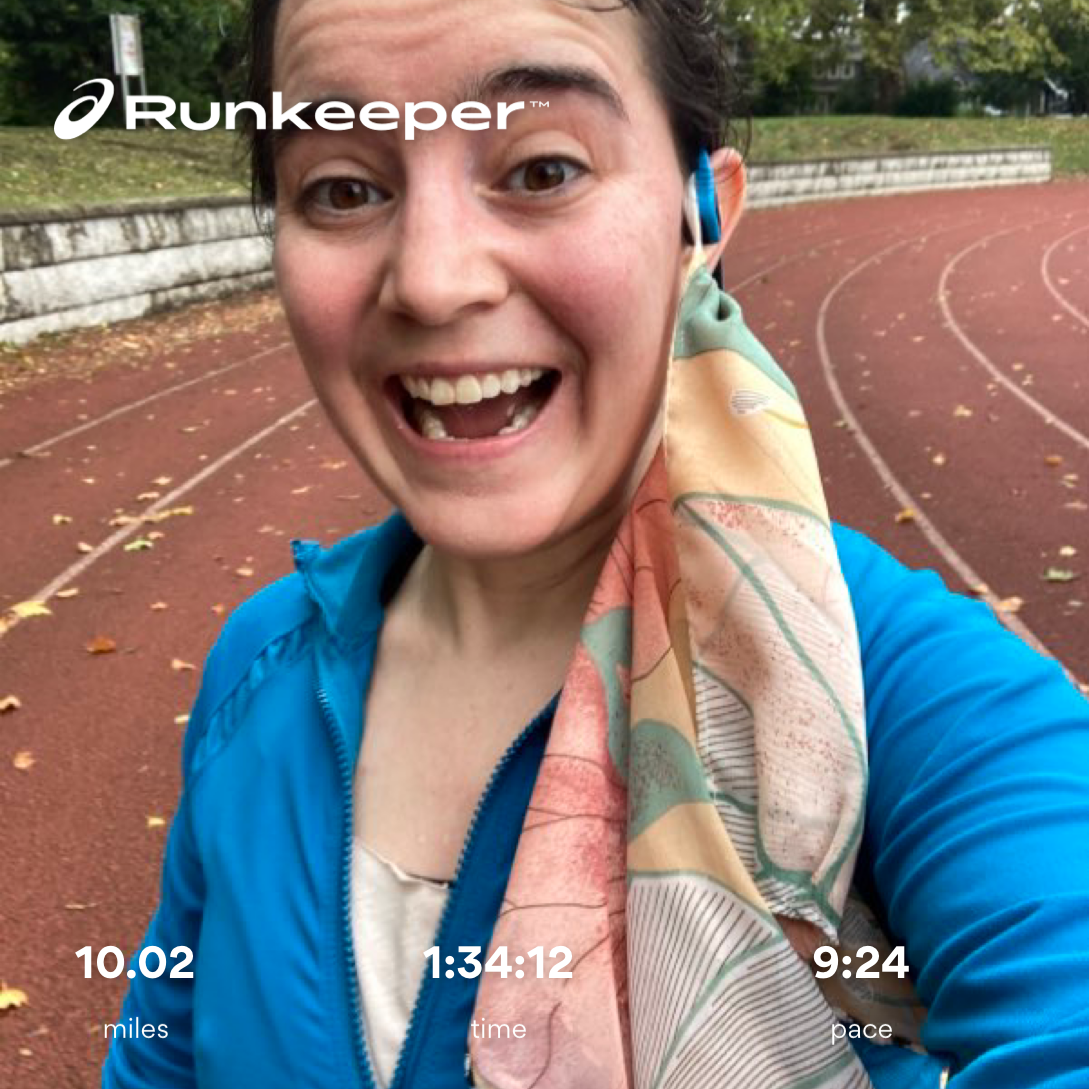 Lillian smiling into the camera on a running track and a mask to one side with an overlay that says "10.02 miles), 1:34:12 total time, 9:24 pace)"